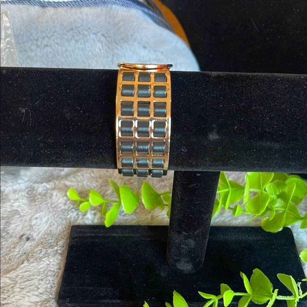 gold bracelet with black leather straps